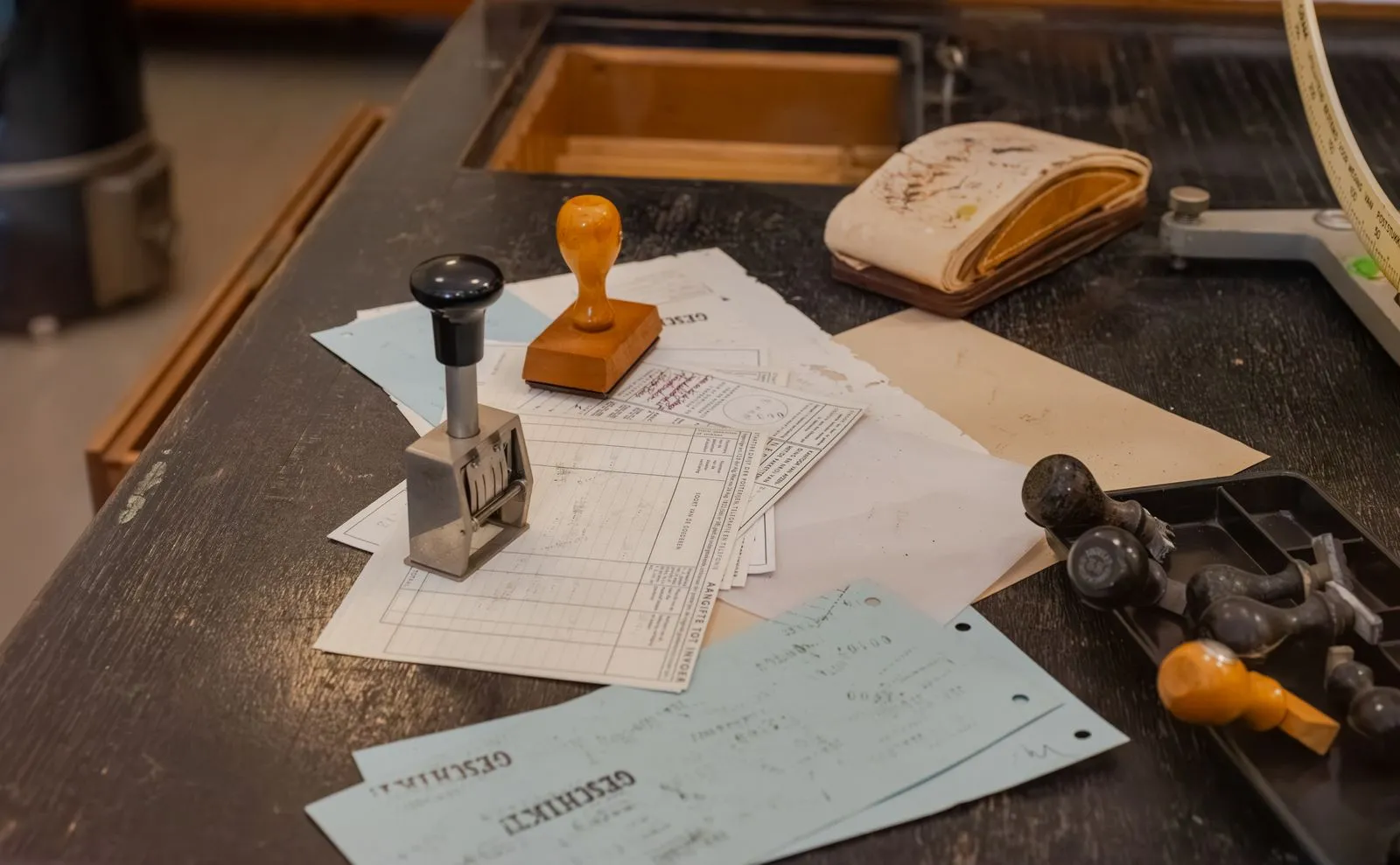 Documentos y timbres administrativos dispuestos sobre un escritorio.