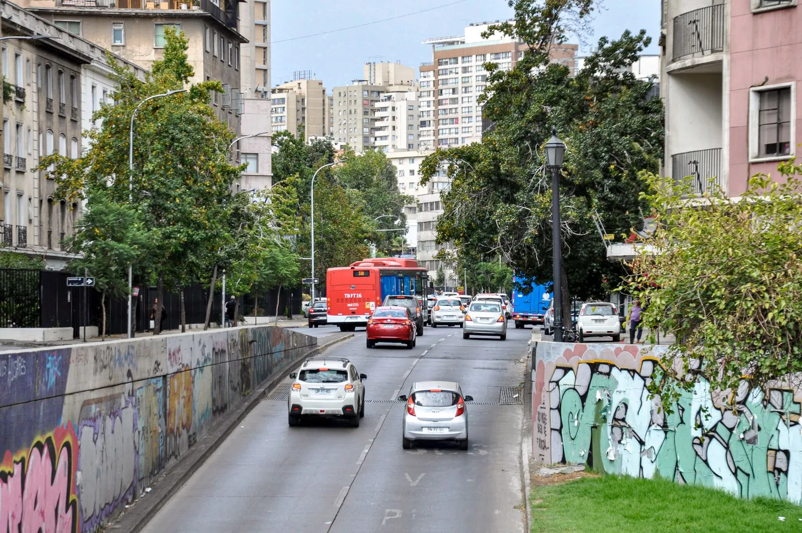 Tránsito de vehículos y transporte público en una calle de Santiago.
