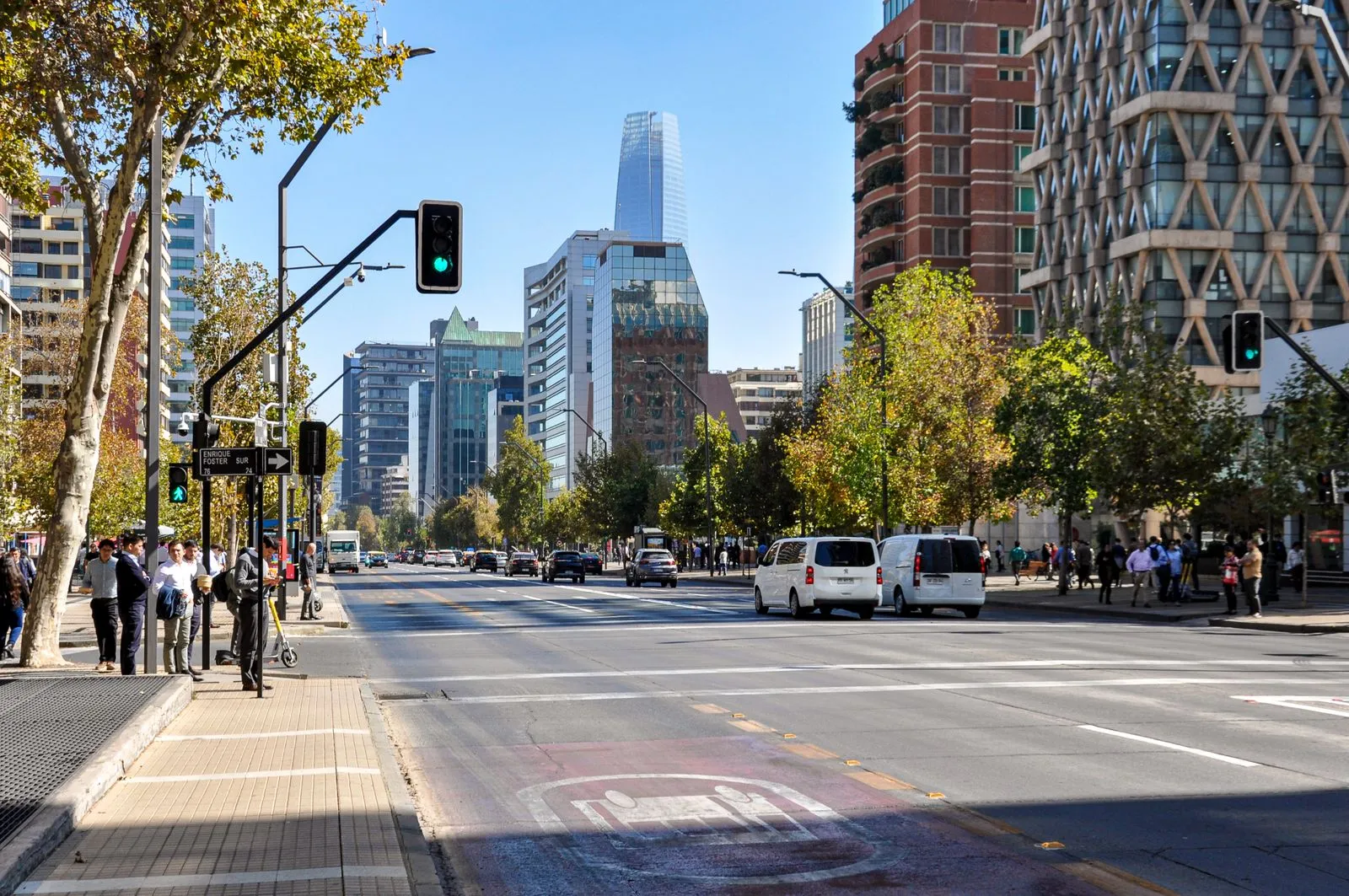 Cruce peatonal y calle urbana de Santiago con personas atravesando la vía.