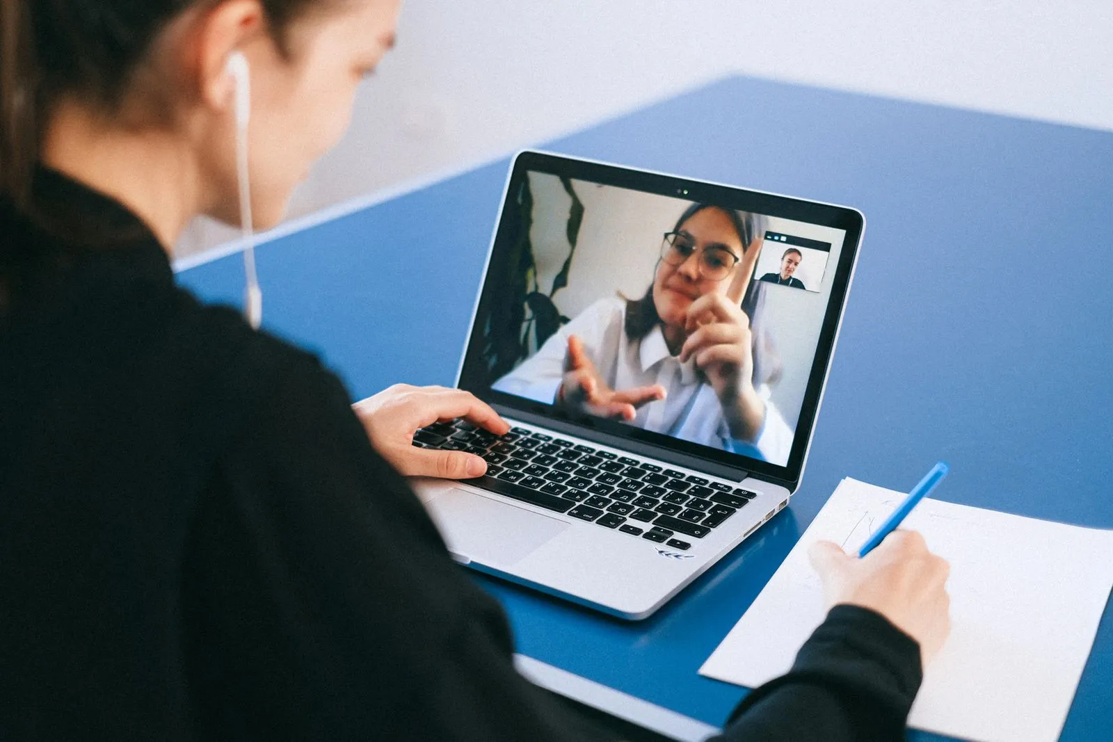 Persona participa en una videoconferencia mediante un computador portátil.
