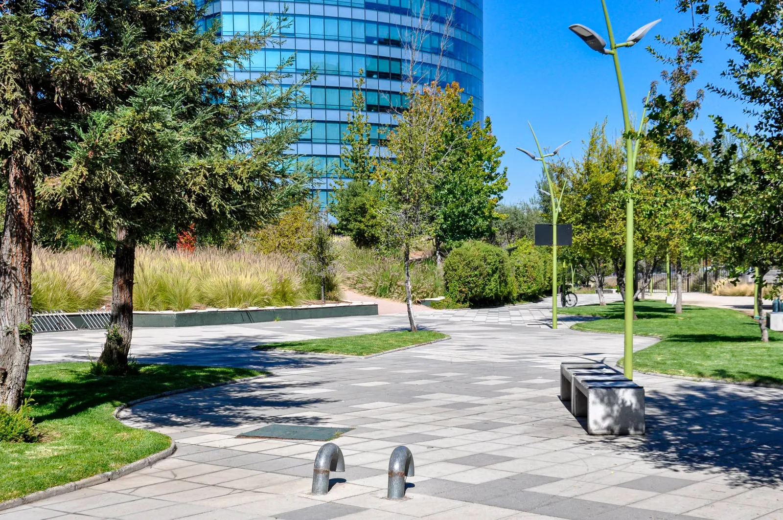 Sendero pavimentado entre jardines y edificios modernos de Santiago.