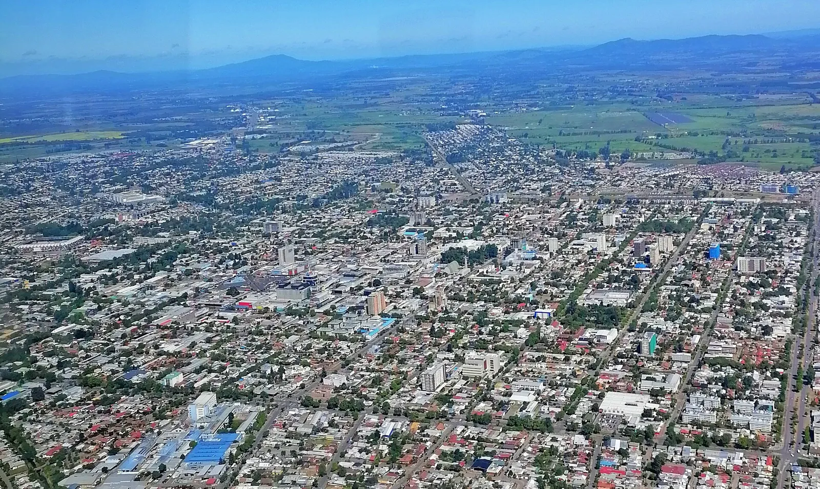 Vista aérea de Chillán, sector de Las Cuatro Avenidas: trama urbana de manzanas y, al fondo, terrenos agrícolas.