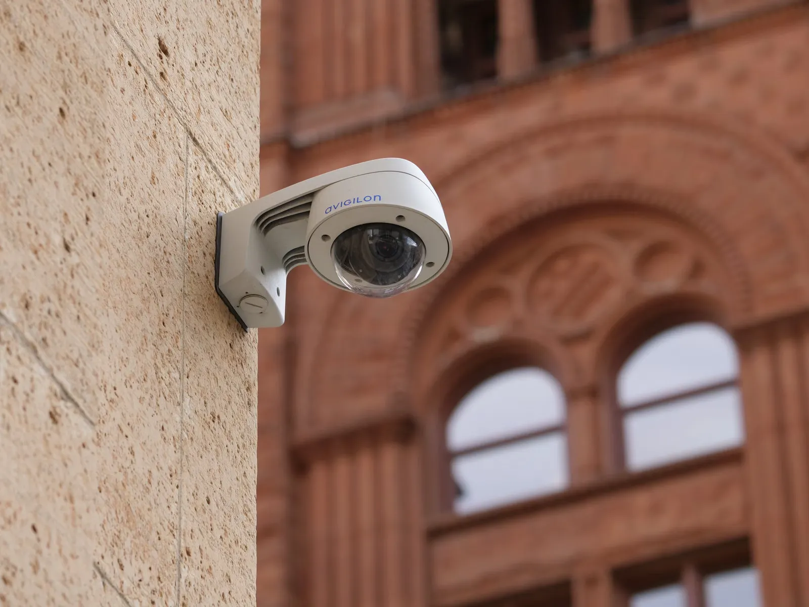 Cámara de vigilancia instalada en la fachada de un edificio urbano.
