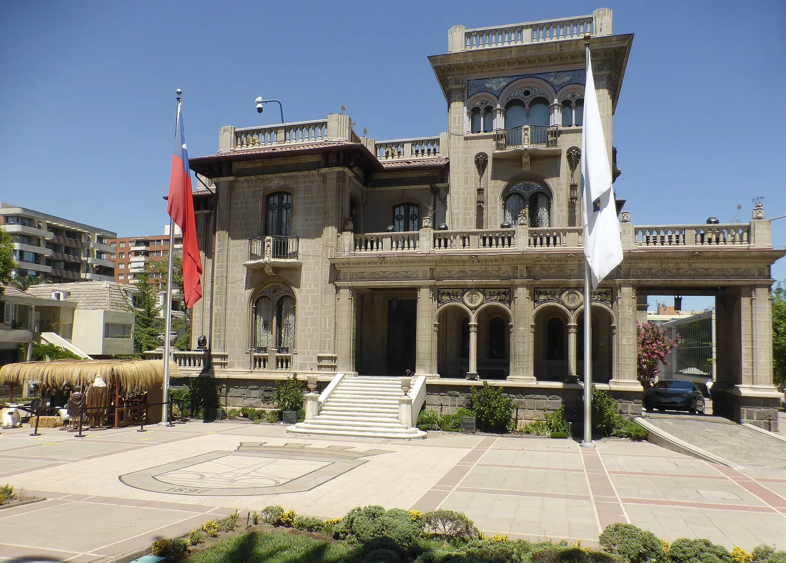 Palacio Falabella, sede de la Municipalidad de Providencia: edificio neorrenacentista de piedra con escalinata central y banderas, en un día despejado.